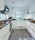 Weiße Küche mit dunkler Arbeitsplatte im Doppelhaus Satteldach Klassik 148 von LUXHAUS