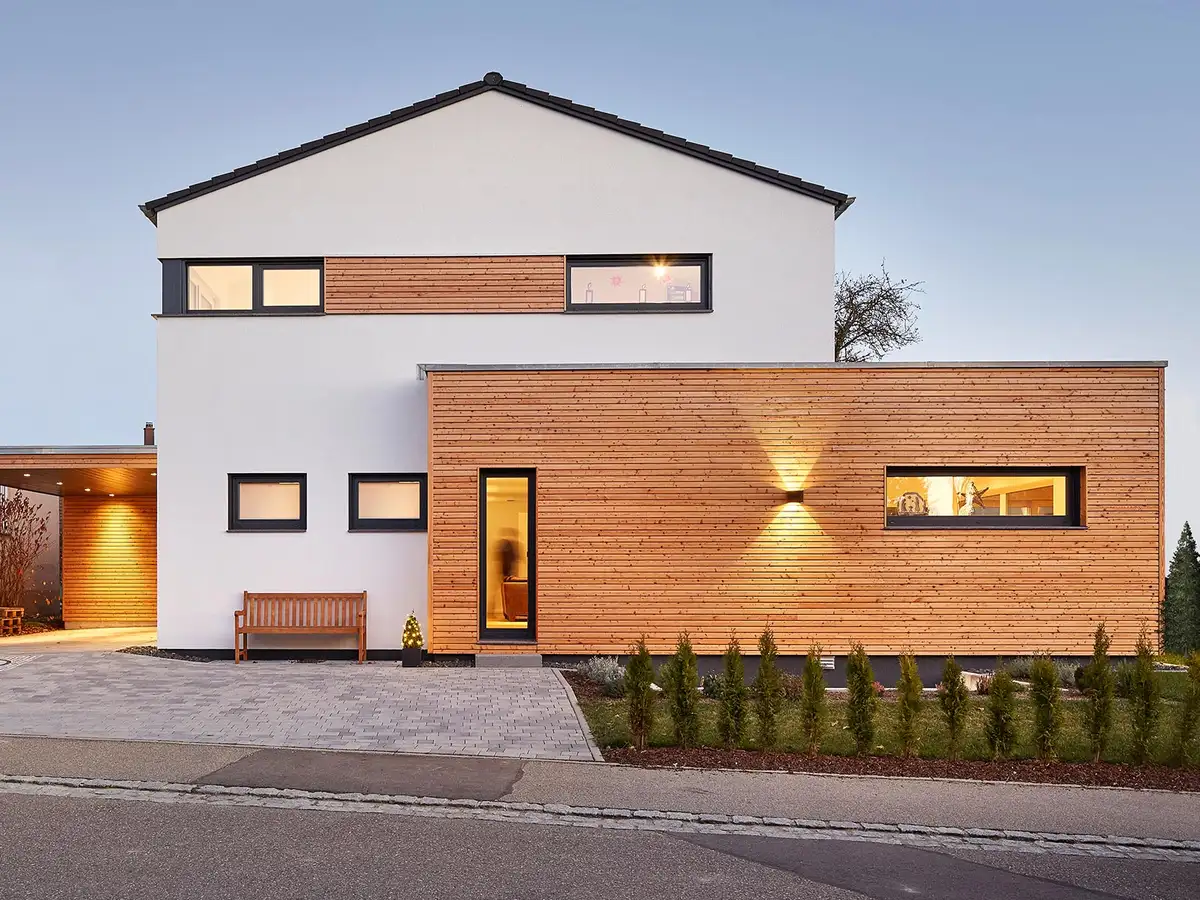 Satteldachhaus mit Holzfassade am Anbau - Außenaufnahme in Dämmerung